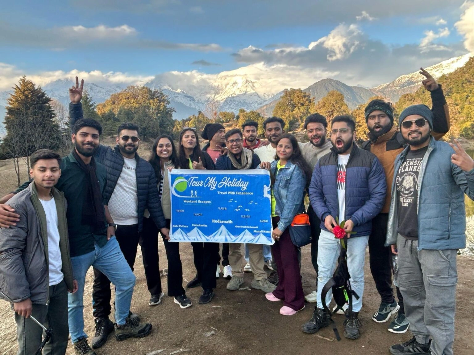Group of friends enjoying scenic Deoriatal Lake surrounded by lush green Himalayan forests in Uttarakhand