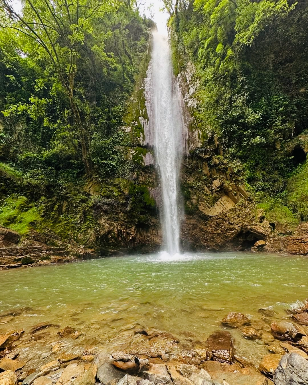 Tiger Waterfall in Chakrata with flowing water, rocky cliffs, and forested surroundings during monsoon