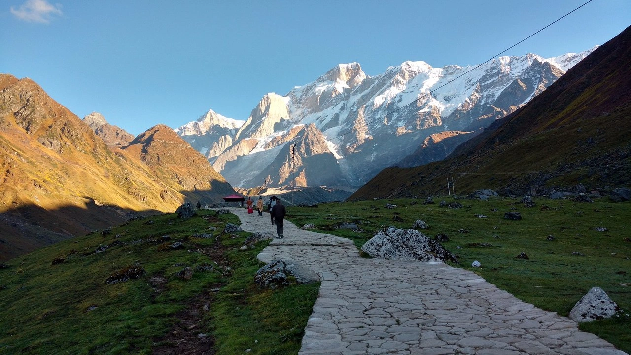 Kedarnath trekking path with Himalayan landscape, pilgrims walking in traditional attire