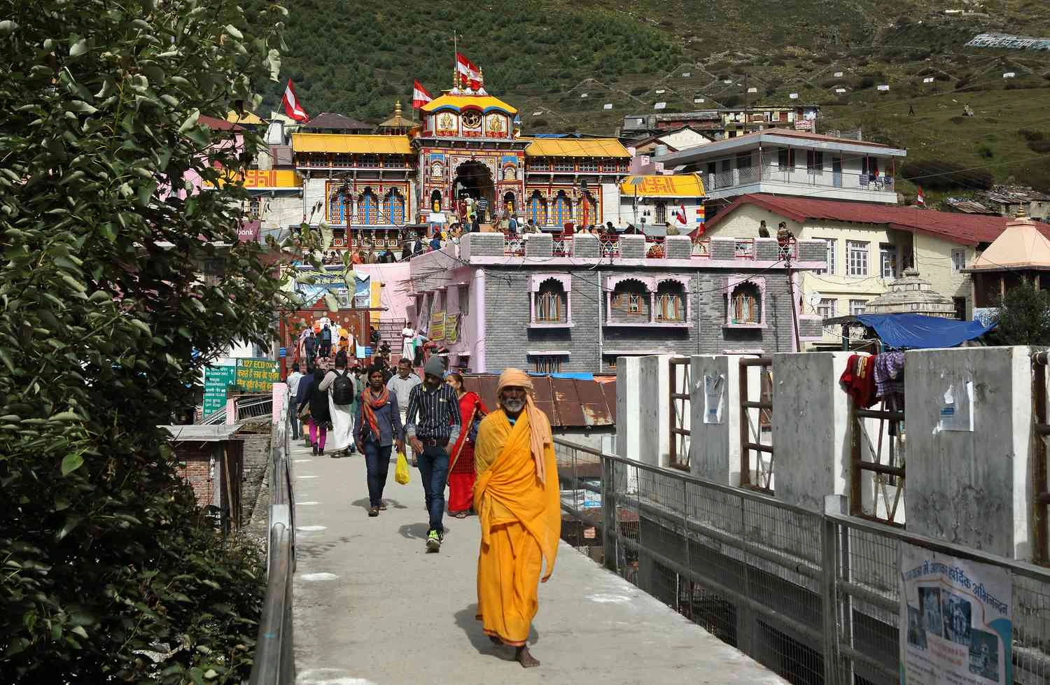 Pilgrims visiting Badrinath Temple for darshan with colorful temple facade and Himalayan mountain backdrop