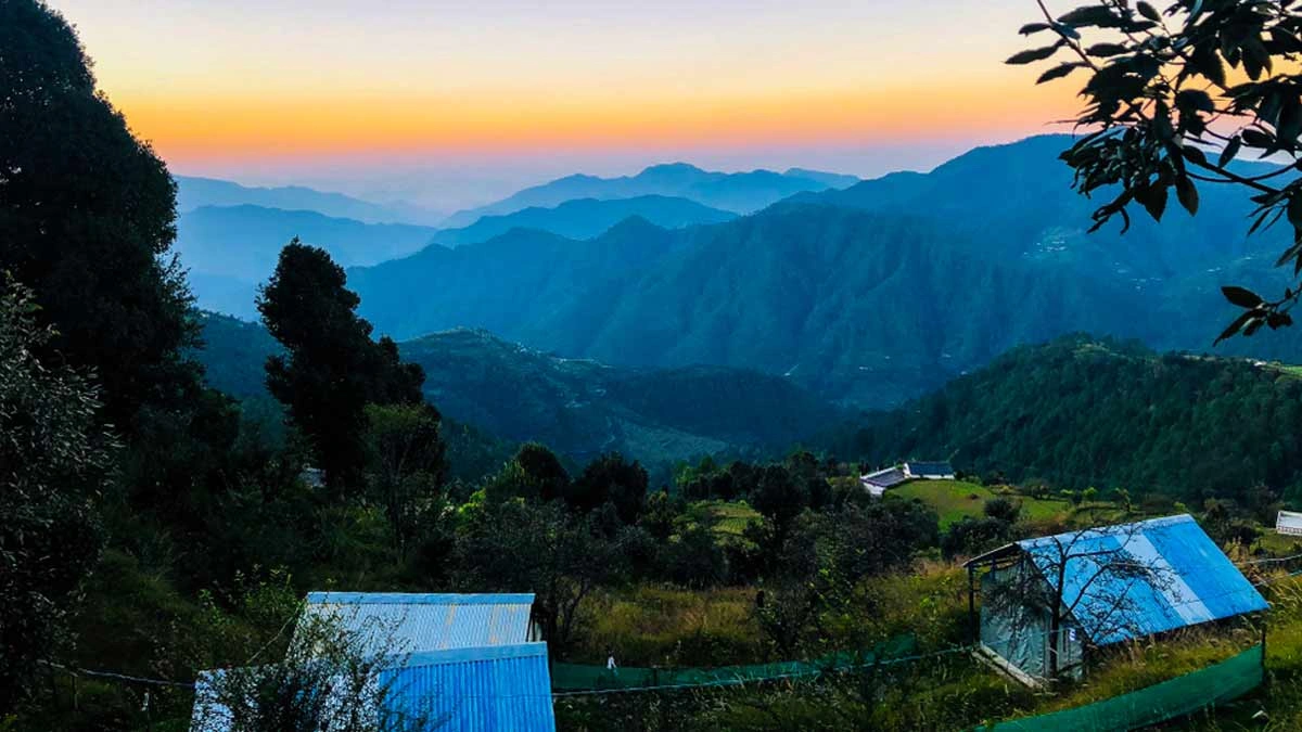 Kanatal landscape with colorful sunset sky, forested hills, and serene natural beauty